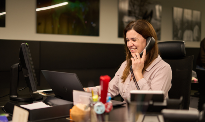 trabalhadora a sorrir ao telefone