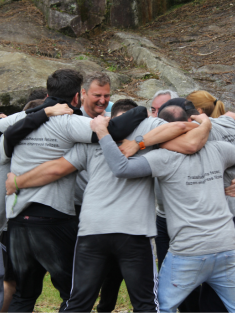 trabalhadores a abraçarem-se em equipa